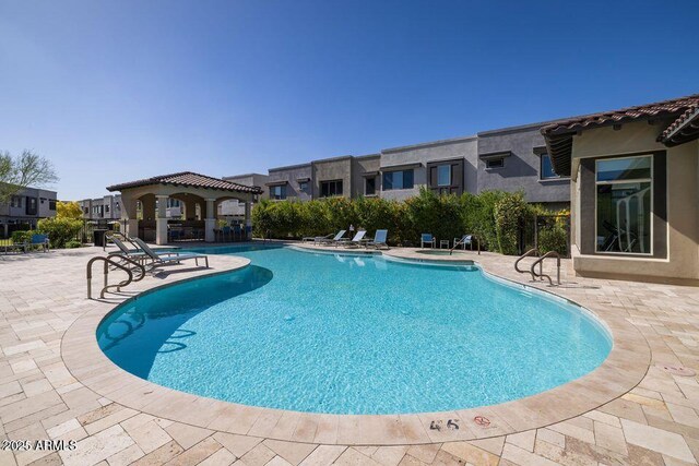 pool featuring a gazebo, a patio area, and a residential view