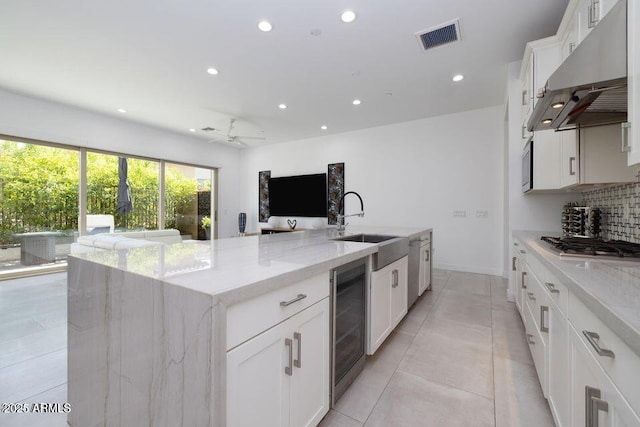 kitchen featuring a sink, wine cooler, recessed lighting, and under cabinet range hood
