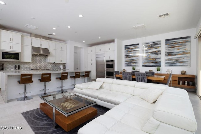 living room featuring recessed lighting, light tile patterned flooring, and visible vents