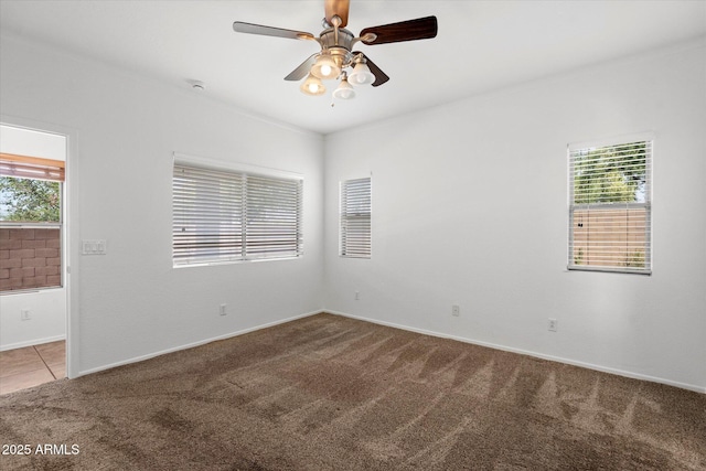 spare room featuring carpet floors, ceiling fan, and baseboards