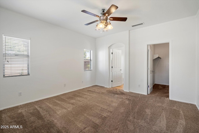 unfurnished bedroom with visible vents, carpet flooring, baseboards, and a walk in closet