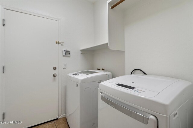 laundry room featuring light tile patterned floors, laundry area, and washing machine and dryer