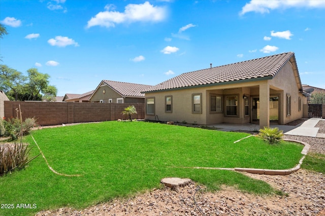 rear view of house featuring a patio, a fenced backyard, stucco siding, and a tile roof