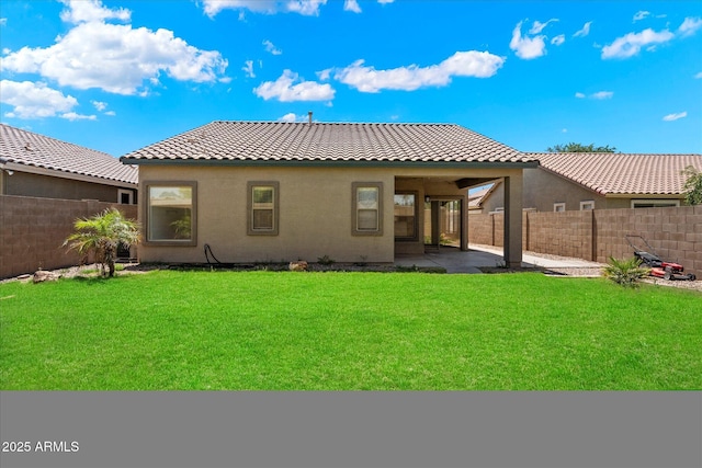 rear view of house with a fenced backyard, stucco siding, and a tile roof