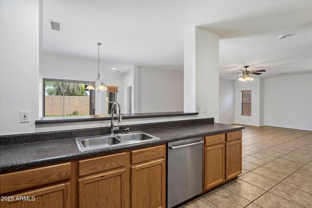 kitchen featuring visible vents, dark countertops, dishwasher, a sink, and light tile patterned flooring