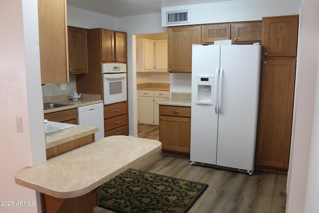 235 N 61st Pl, Mesa, AZ 85205 - kitchen featuring white appliances, wood finished floors, light countertops, and a peninsula
