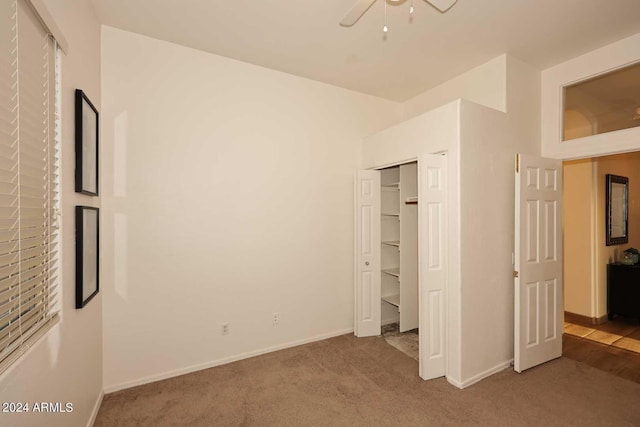 unfurnished bedroom featuring carpet, ceiling fan, and a closet