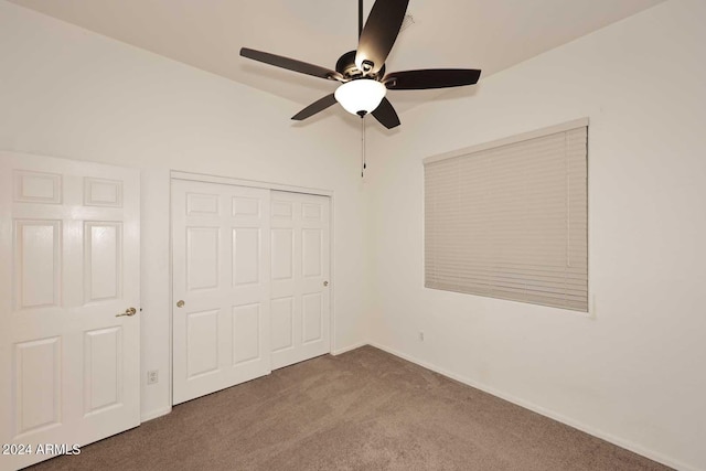 unfurnished bedroom with ceiling fan, a closet, carpet floors, and vaulted ceiling