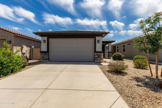 17437 W Via De Luna Dr, Surprise, AZ 85387 - prairie-style house with an attached garage, stucco siding, driveway, and stone siding