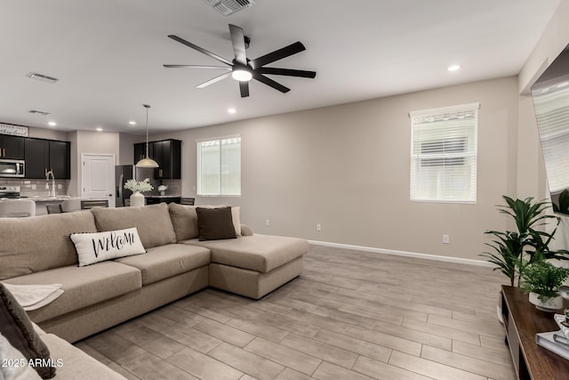 17437 W Via De Luna Dr, Surprise, AZ 85387 - living area featuring visible vents, baseboards, recessed lighting, a ceiling fan, and light wood finished floors