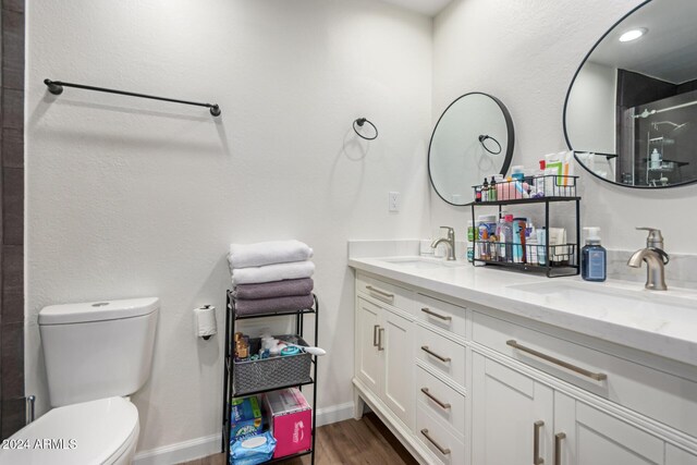 12043 N 46th Ave, Glendale, AZ 85304 - full bathroom with wood finished floors, double vanity, toilet, a shower with door, and baseboards