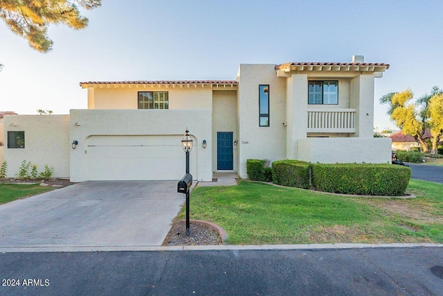 mediterranean / spanish-style home with a garage and a front lawn