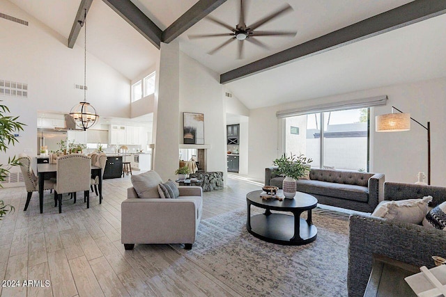 living room with ceiling fan with notable chandelier, high vaulted ceiling, and beamed ceiling