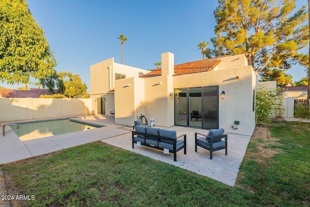 rear view of house featuring an outdoor living space, a fenced in pool, a patio, and a yard