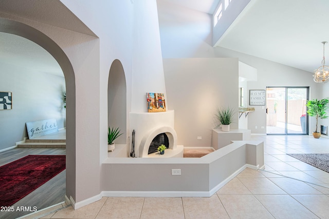 11025 N 10th St, Phoenix, AZ 85020 - hallway featuring high vaulted ceiling, tile patterned floors, a chandelier, and arched walkways