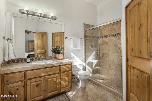 full bathroom featuring a stall shower, vanity, and toilet