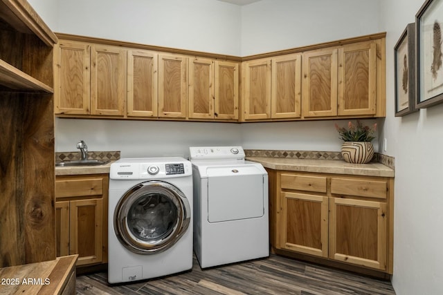 laundry area featuring dark wood-style floors, cabinet space, a sink, and washer and clothes dryer