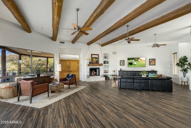 living area with a large fireplace, visible vents, beamed ceiling, and wood finished floors