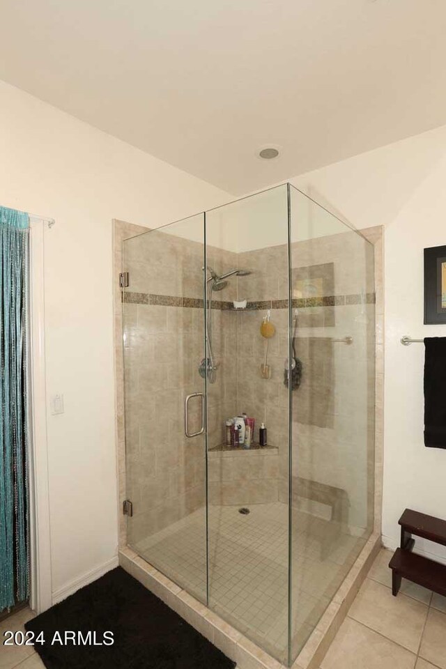 bathroom featuring a shower with shower door and tile patterned flooring