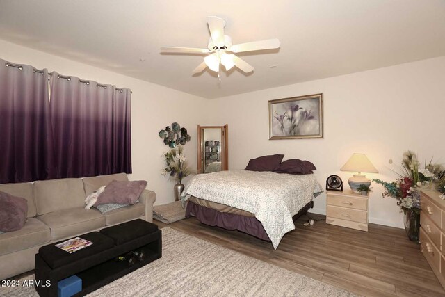 bedroom with ceiling fan and hardwood / wood-style flooring