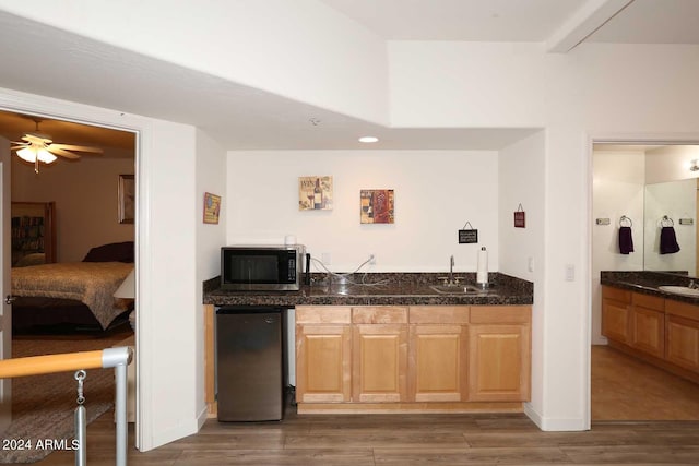 bar with ceiling fan, appliances with stainless steel finishes, dark hardwood / wood-style floors, and sink