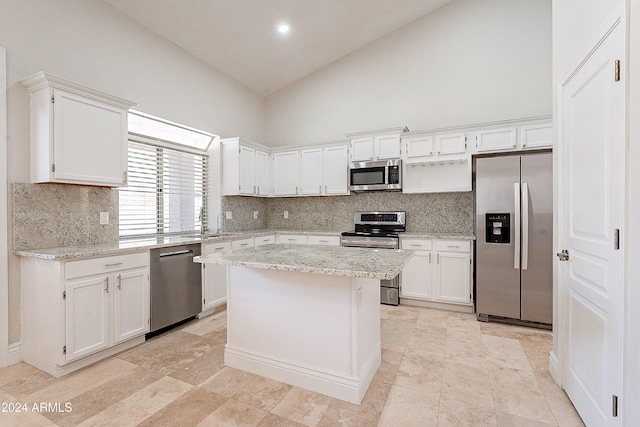 kitchen featuring white cabinets, stainless steel appliances, and high vaulted ceiling