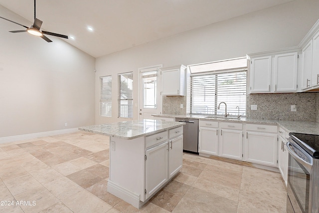 kitchen with sink, a center island, lofted ceiling, white cabinets, and appliances with stainless steel finishes