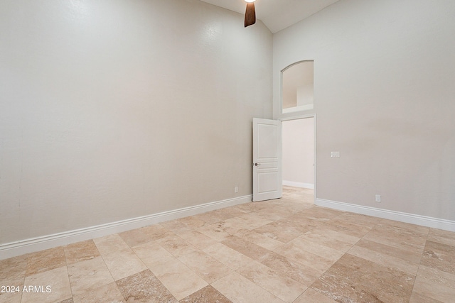 empty room featuring ceiling fan and vaulted ceiling