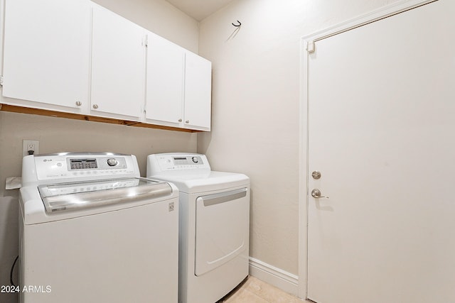 laundry room with light tile patterned flooring, cabinets, and independent washer and dryer