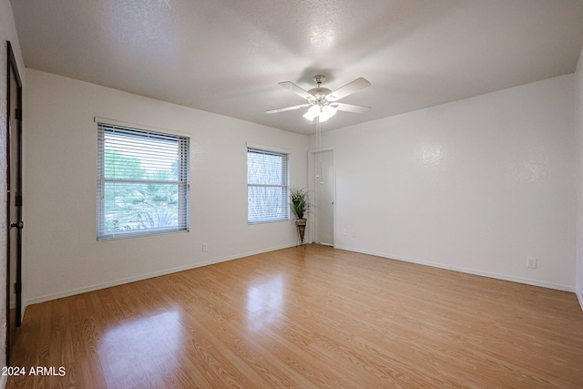 spare room with ceiling fan and light wood-type flooring