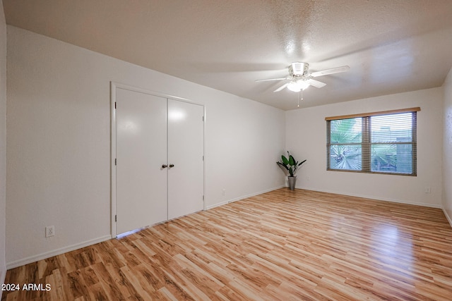 unfurnished room featuring ceiling fan, light hardwood / wood-style floors, and a textured ceiling