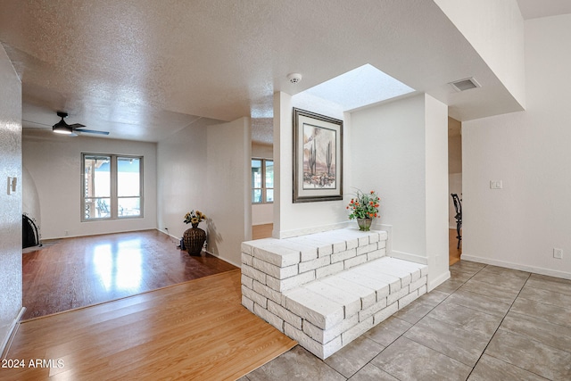 corridor featuring light hardwood / wood-style floors and a textured ceiling