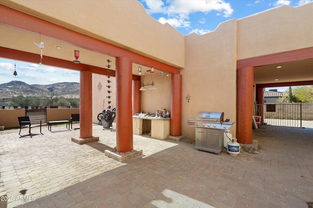 view of patio featuring a grill, fence, and a mountain view