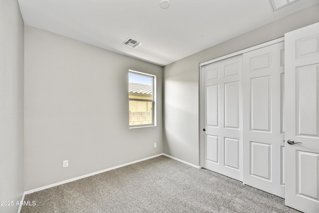 unfurnished bedroom featuring a closet, visible vents, baseboards, and carpet floors