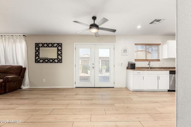 interior space featuring white cabinets, visible vents, dishwasher, and light wood finished floors