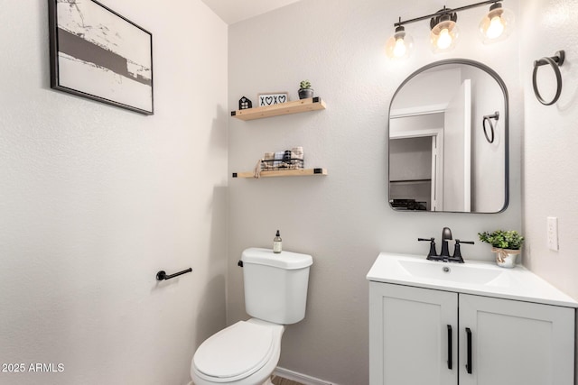 bathroom with vanity, toilet, and baseboards