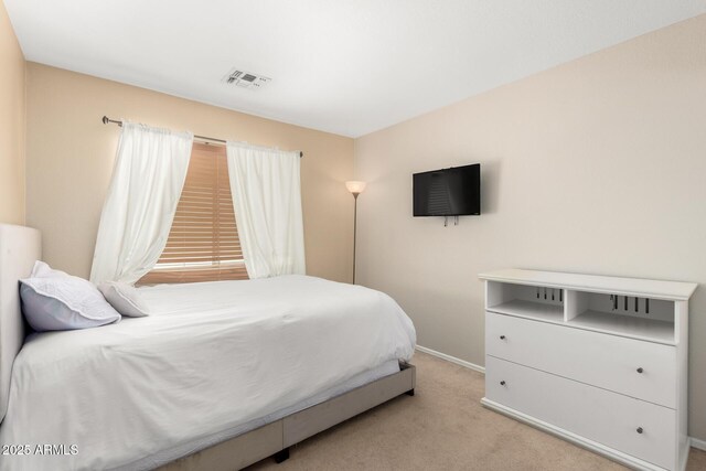 bedroom with light carpet, visible vents, and baseboards