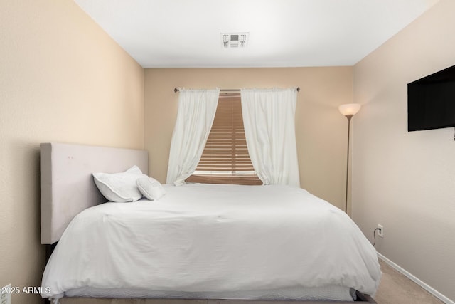 carpeted bedroom featuring baseboards and visible vents