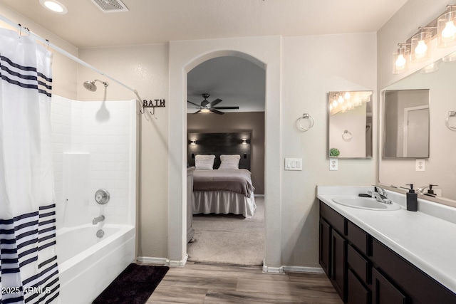 full bathroom featuring a ceiling fan, shower / tub combo, vanity, wood finished floors, and baseboards