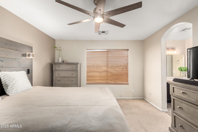 bedroom with arched walkways, baseboards, visible vents, and light colored carpet