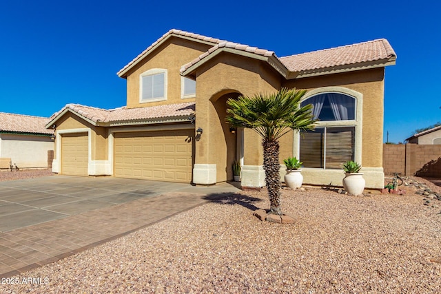 mediterranean / spanish home with driveway, a tiled roof, and stucco siding