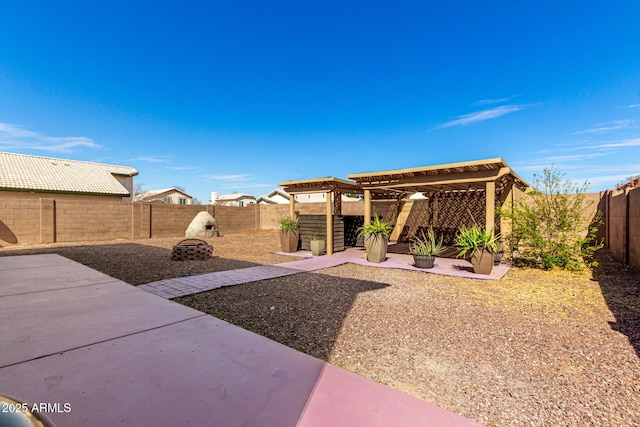 view of yard with a patio area, a fenced backyard, an outdoor fire pit, and a pergola