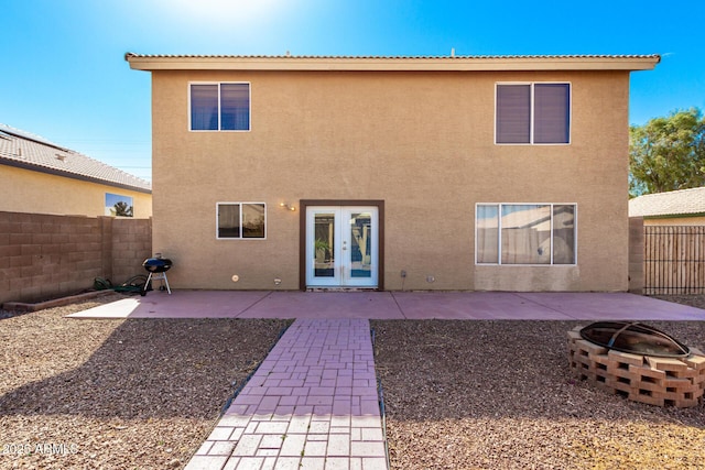 rear view of house featuring an outdoor fire pit, a fenced backyard, french doors, stucco siding, and a patio area