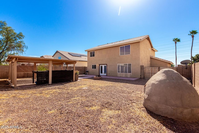 rear view of property with french doors, a fenced backyard, and stucco siding