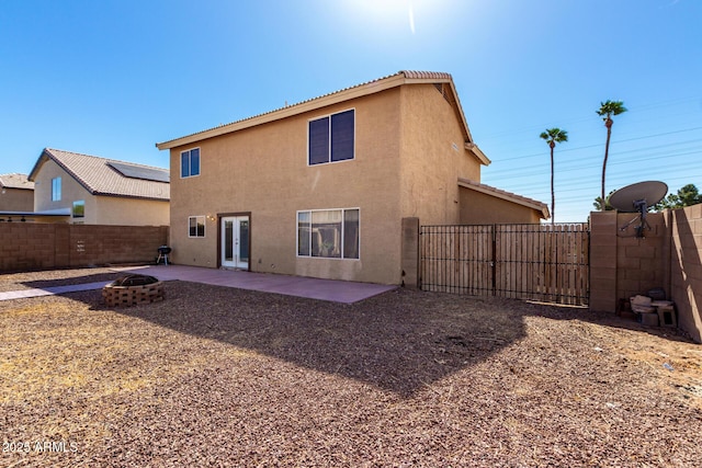 back of house with an outdoor fire pit, a fenced backyard, french doors, stucco siding, and a patio area