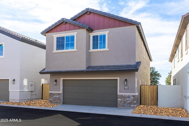 view of front of home with an attached garage, stone siding, concrete driveway, and stucco siding