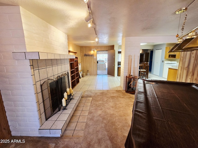 4950 Raffaele Dr, Sierra Vista, AZ 85635 - living room featuring light carpet, a tiled fireplace, a textured ceiling, light tile patterned floors, and rail lighting