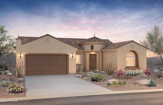 mediterranean / spanish house with a garage, concrete driveway, and stucco siding