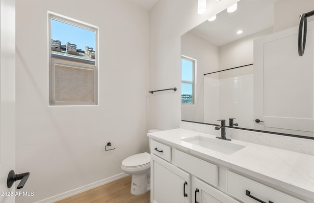 bathroom with a shower, wood finished floors, a wealth of natural light, and baseboards