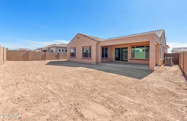 rear view of property featuring cooling unit, a patio area, a fenced backyard, and stucco siding